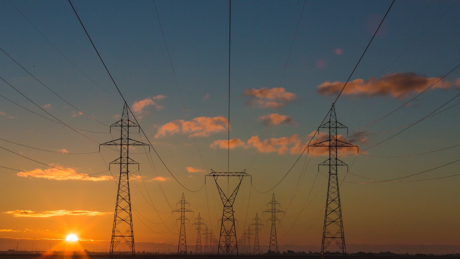 High voltage power lines at sunset representing the grid constraint behind AI data centers and SpaceX infrastructure